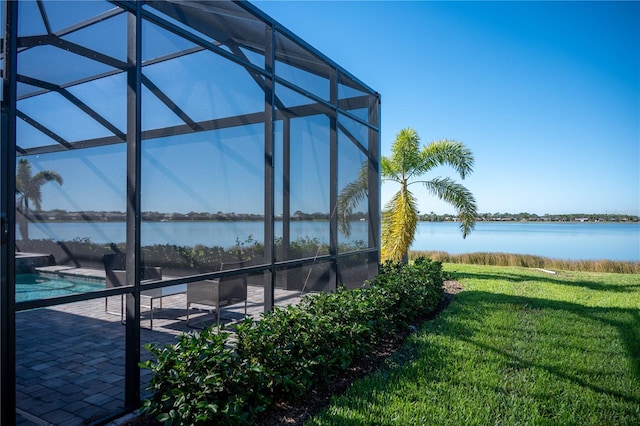 view of pool featuring a water view, glass enclosure, a patio area, and a lawn