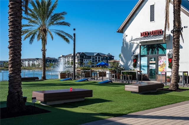 view of community with a yard and a water view