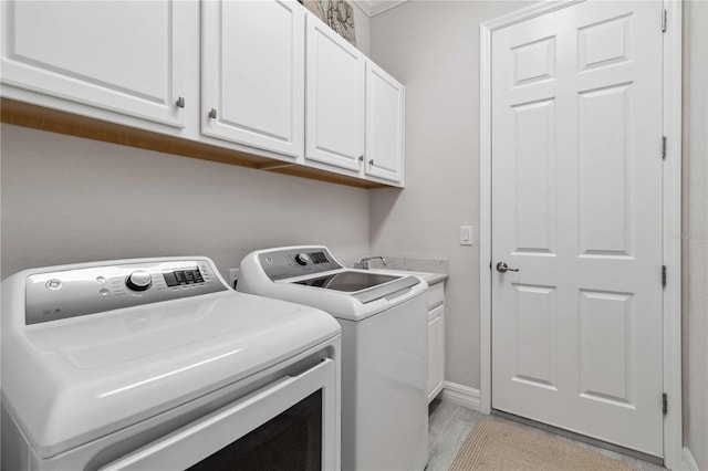 laundry room with washer and dryer and cabinets