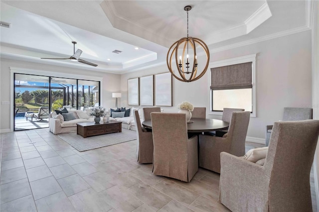 dining area with ceiling fan with notable chandelier, ornamental molding, and a tray ceiling