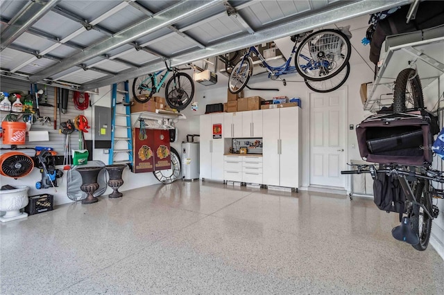 garage featuring electric panel, electric water heater, and a garage door opener