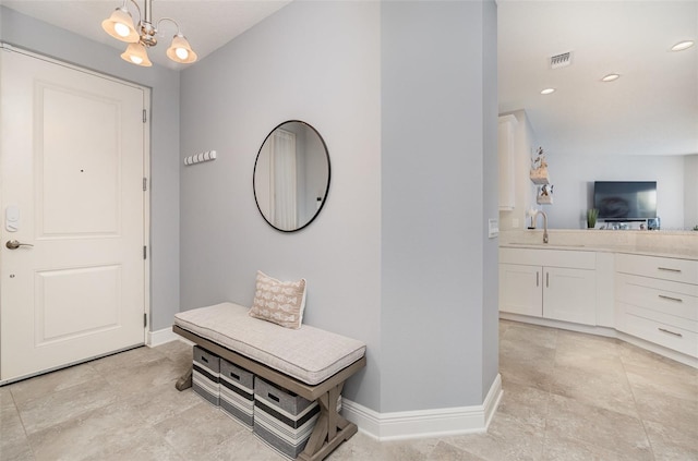 entryway with sink and a notable chandelier