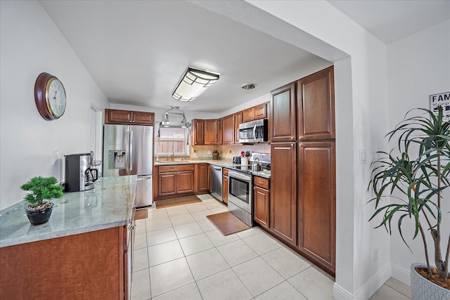 kitchen featuring light tile patterned flooring, appliances with stainless steel finishes, light stone countertops, and sink