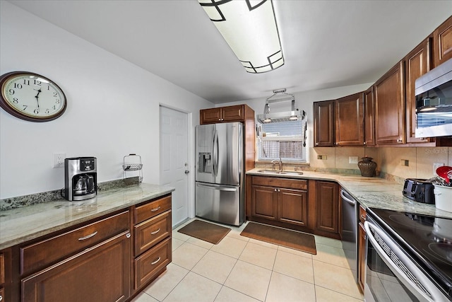 kitchen featuring backsplash, light tile patterned floors, sink, and appliances with stainless steel finishes