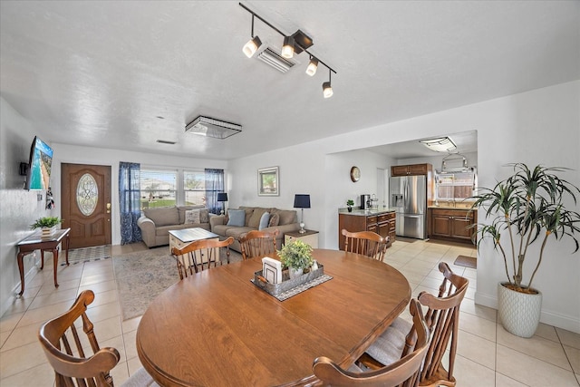 tiled dining room featuring rail lighting