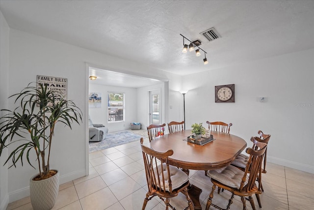 tiled dining room with a textured ceiling