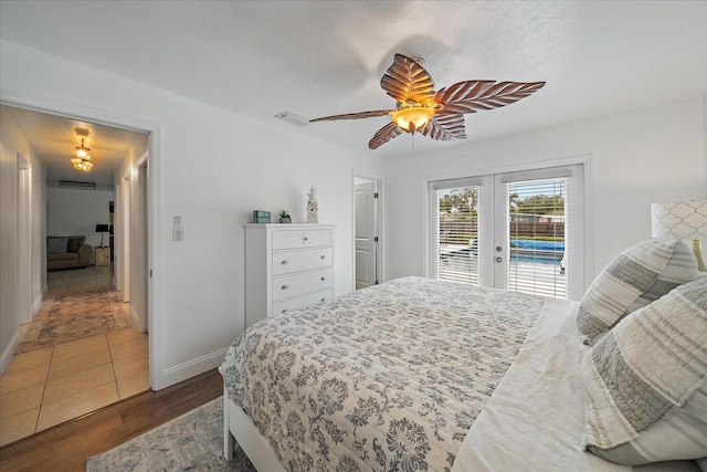 bedroom with access to exterior, ceiling fan, french doors, and dark wood-type flooring