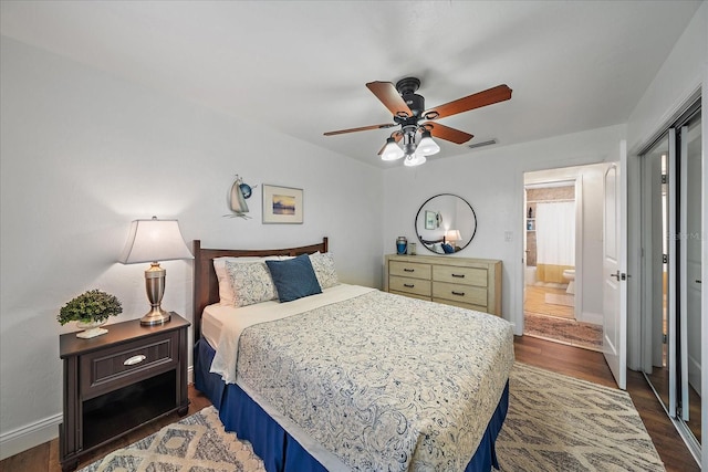 bedroom with connected bathroom, ceiling fan, and dark wood-type flooring