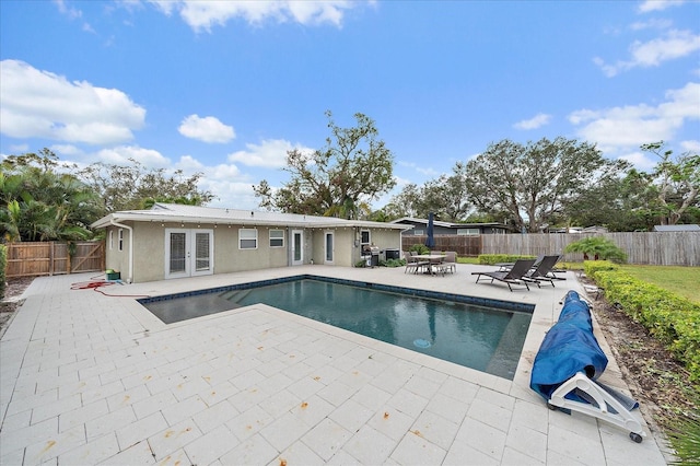 view of swimming pool with a patio and french doors