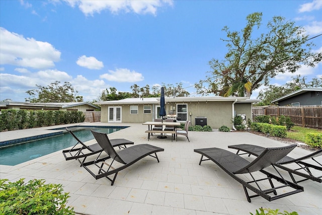 view of pool with french doors, a patio, and central AC unit