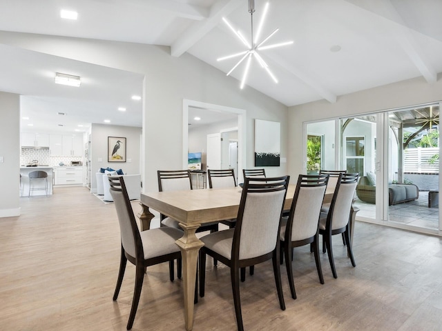 dining area featuring lofted ceiling with beams and light wood-type flooring