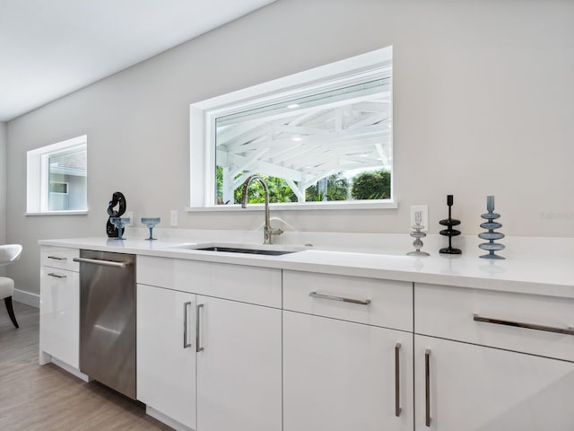 kitchen featuring dishwasher, white cabinets, light hardwood / wood-style floors, and sink