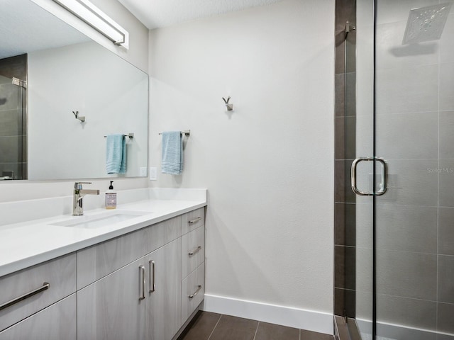 bathroom featuring a textured ceiling, vanity, tile patterned floors, and an enclosed shower