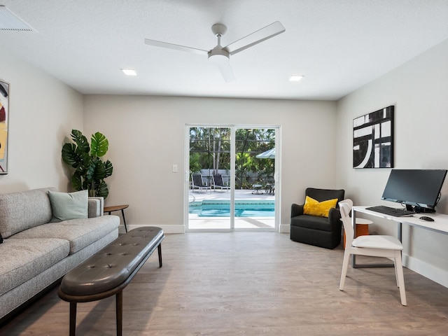 living room featuring hardwood / wood-style flooring and ceiling fan