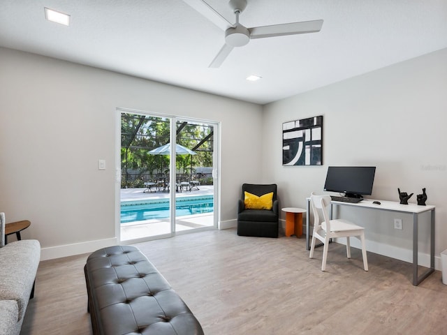 home office with light wood-type flooring and ceiling fan