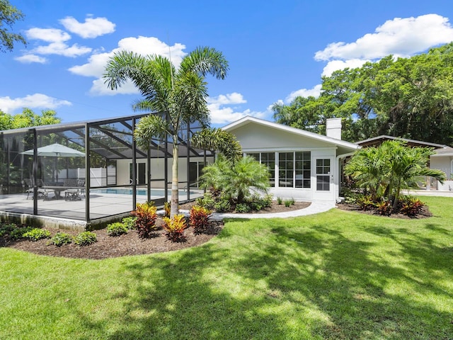 back of house featuring a lanai, a yard, and a patio