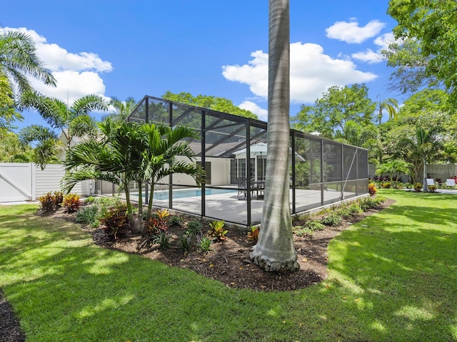 exterior space with a lanai, a lawn, and a fenced in pool