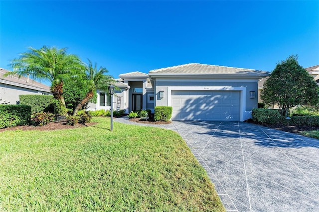 ranch-style home featuring a garage and a front lawn