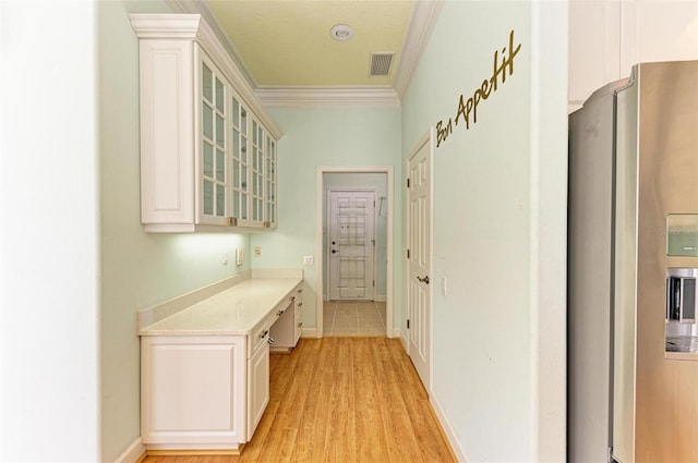 hall featuring ornamental molding, a textured ceiling, and light hardwood / wood-style flooring