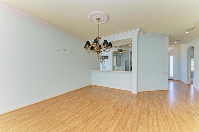 empty room featuring crown molding, light hardwood / wood-style flooring, a chandelier, and a textured ceiling