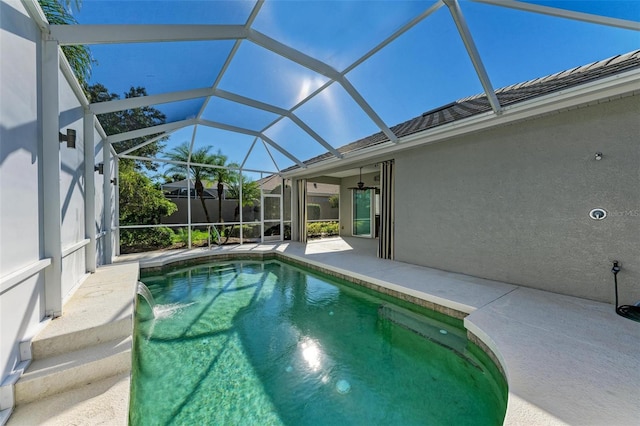 view of pool with a lanai, a patio area, and pool water feature