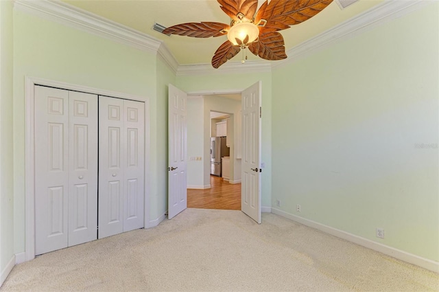 unfurnished bedroom featuring stainless steel refrigerator, ceiling fan, crown molding, light carpet, and a closet