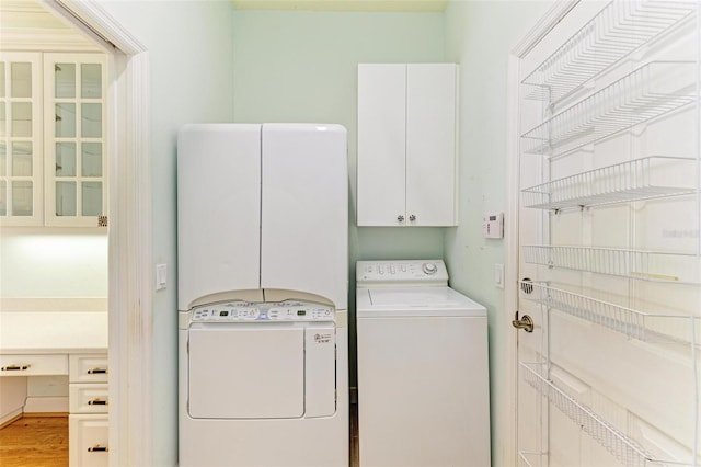 laundry area featuring cabinets, light hardwood / wood-style flooring, and washer and clothes dryer