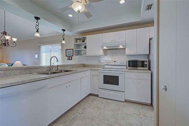 kitchen with sink, hanging light fixtures, tasteful backsplash, white appliances, and white cabinets