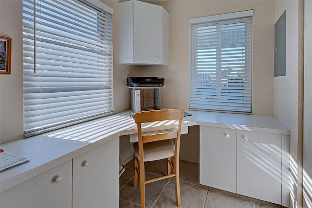 office space featuring light tile patterned floors, built in desk, and electric panel