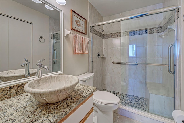 bathroom with walk in shower, vanity, and toilet