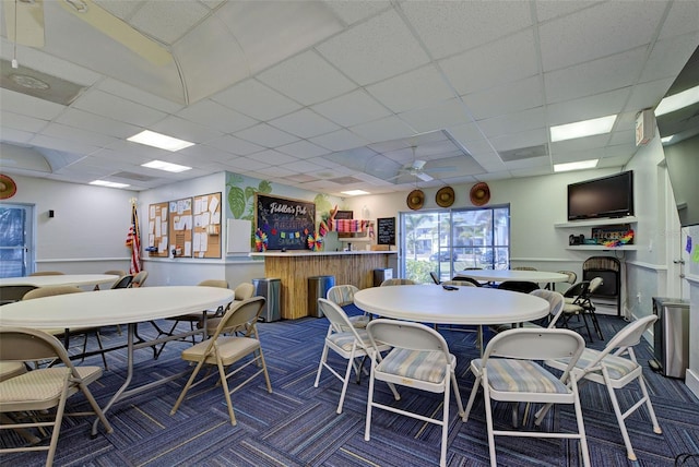 dining room with ceiling fan and a drop ceiling