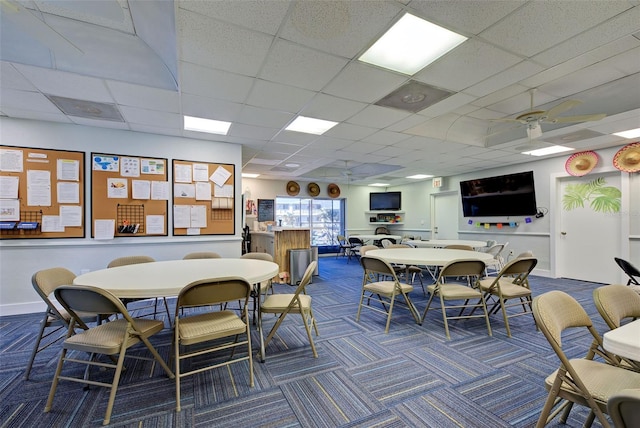 dining room featuring a paneled ceiling, ceiling fan, and dark colored carpet