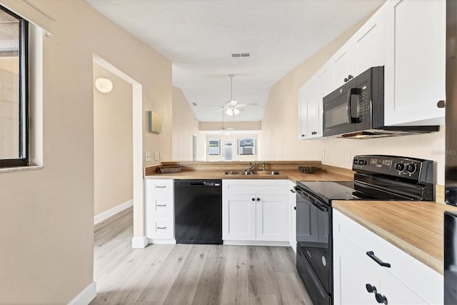 kitchen with white cabinets, light wood-type flooring, sink, and black appliances