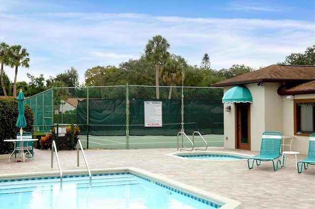 view of pool with tennis court and a community hot tub