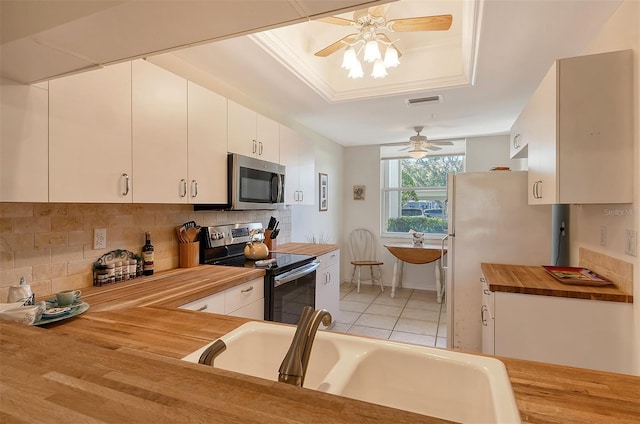 8755 Olde Hickory Ave Unit 7101, Sarasota, FL 34238 - kitchen with stainless steel appliances, butcher block countertops, ceiling fan, backsplash, and white cabinetry