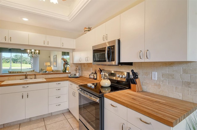 8755 Olde Hickory Ave Unit 7101, Sarasota, FL 34238 - kitchen with appliances with stainless steel finishes, butcher block counters, a raised ceiling, tasteful backsplash, and light tile patterned floors