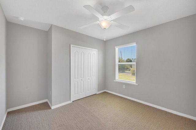 unfurnished bedroom featuring carpet flooring, a closet, and ceiling fan