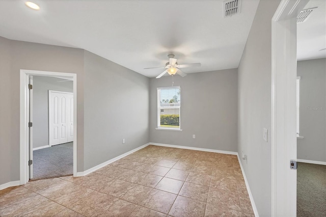 spare room with ceiling fan and light tile patterned flooring