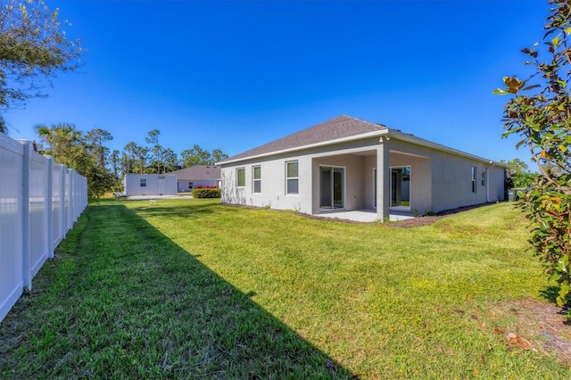 back of property with a patio area and a yard