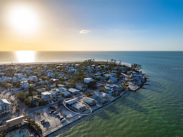 aerial view at dusk featuring a water view