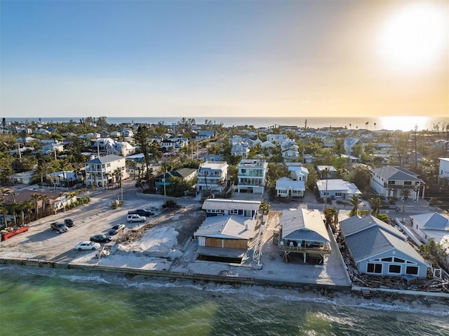 aerial view at dusk featuring a water view