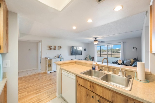 kitchen with dishwasher, sink, ceiling fan, a textured ceiling, and light hardwood / wood-style floors