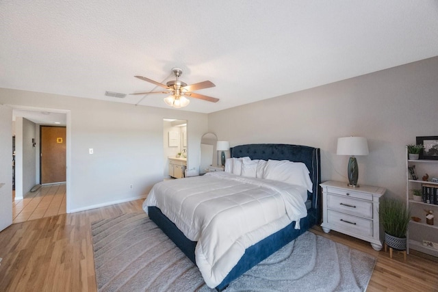 bedroom with a textured ceiling, light wood-type flooring, and ceiling fan