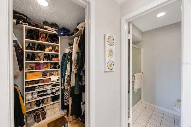 spacious closet with light tile patterned floors