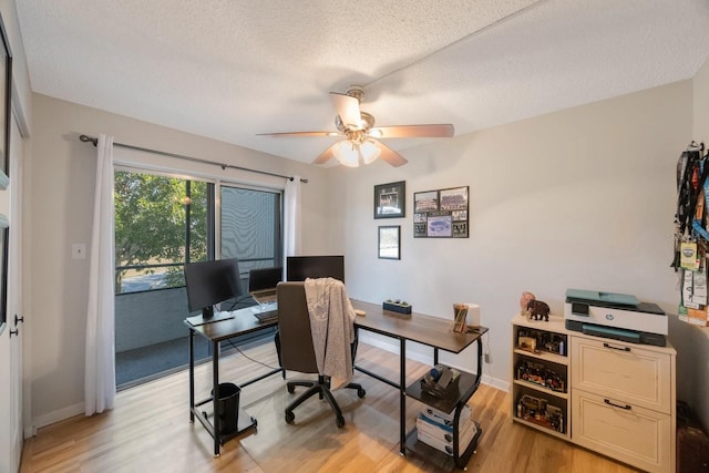 office space with ceiling fan, a textured ceiling, and light wood-type flooring