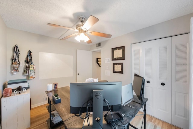 office featuring a textured ceiling, light hardwood / wood-style floors, and ceiling fan