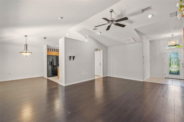 unfurnished living room with hardwood / wood-style flooring, ceiling fan with notable chandelier, and vaulted ceiling