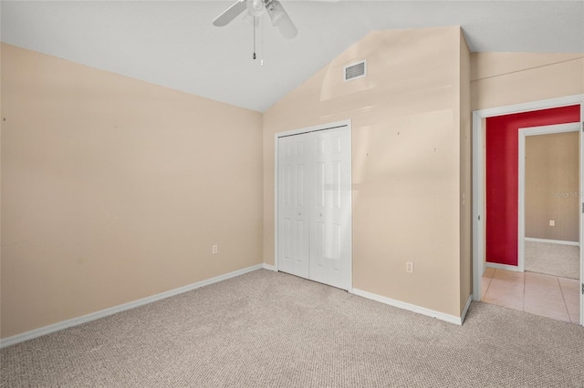 unfurnished bedroom with carpet, a closet, ceiling fan, and lofted ceiling