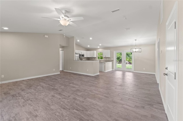 unfurnished living room featuring ceiling fan, french doors, lofted ceiling, and light wood-type flooring