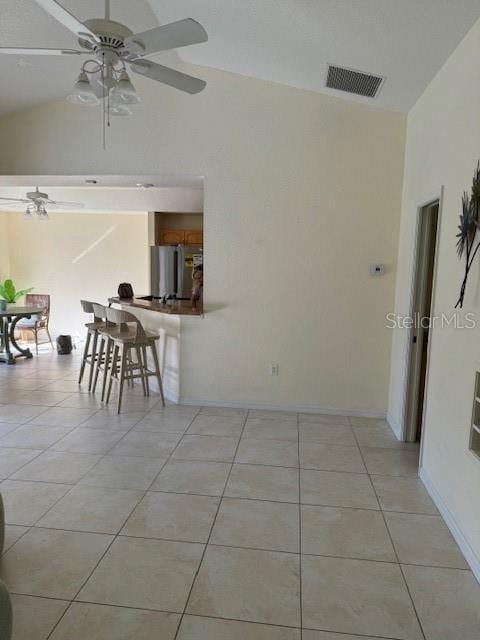 unfurnished dining area featuring ceiling fan, light tile patterned flooring, and lofted ceiling